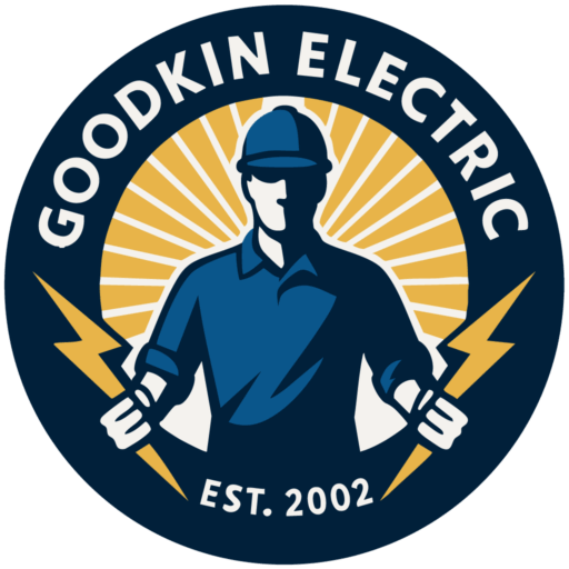 Logo for Goodkin Electric featuring a worker in a hard hat holding two lightning bolts, with rays in the background and "Est. 2002" at the bottom—a bold design that highlights the Goodkin name.