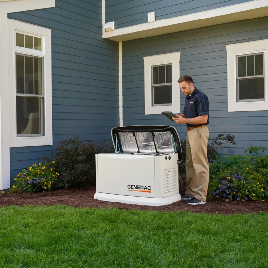 Home_Standby_Generator_Install_Image A man stands next to an open Generac generator outside a blue house, inspecting it with a clipboard in hand.